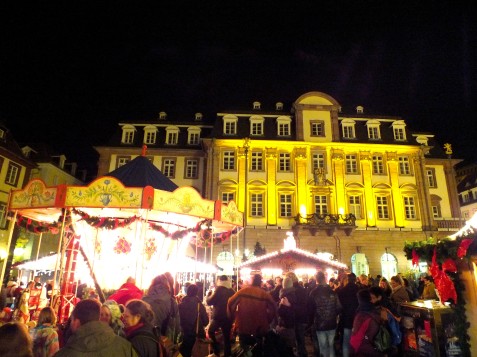 The town hall shines in a golden glow behind one part of the market